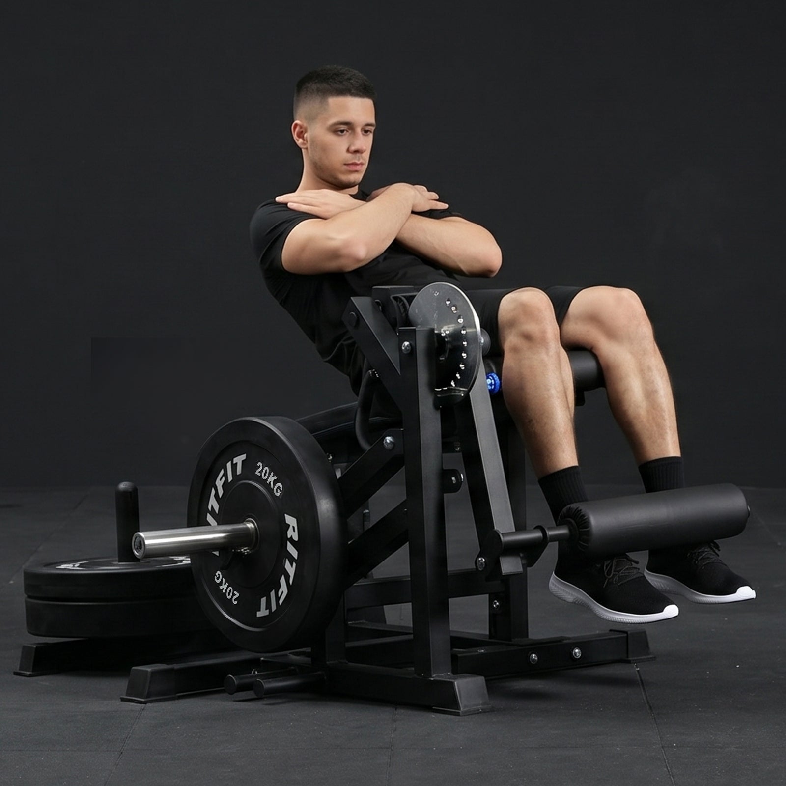 Mann sitzt auf schwarzerRitFit PLC01 Beinstrecker und Beinbeuger Maschine mit Hantelscheiben