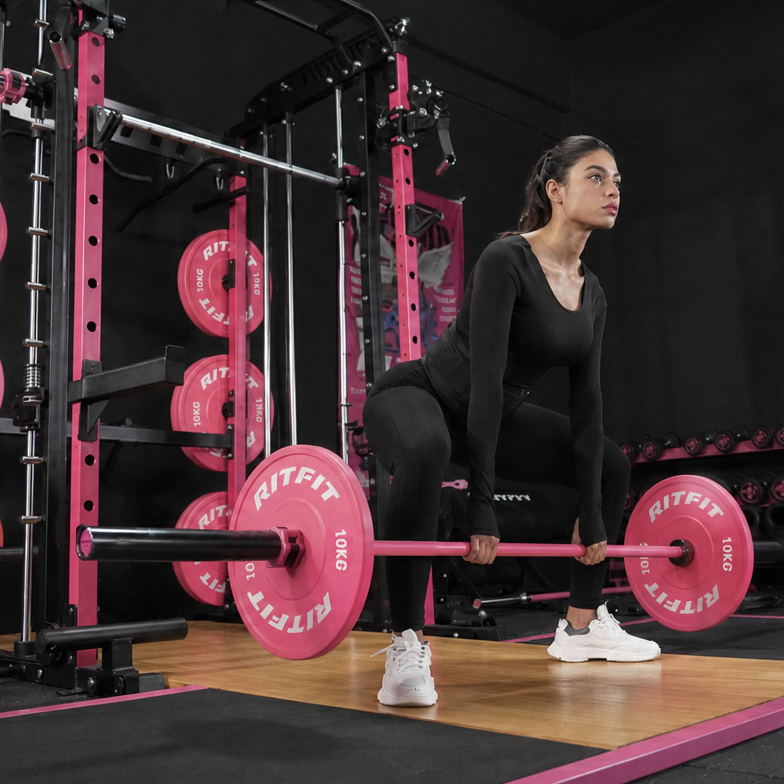 Sportlerin hebt rosa RitFit Trainings-Langhantel beim Training im Fitnessstudio