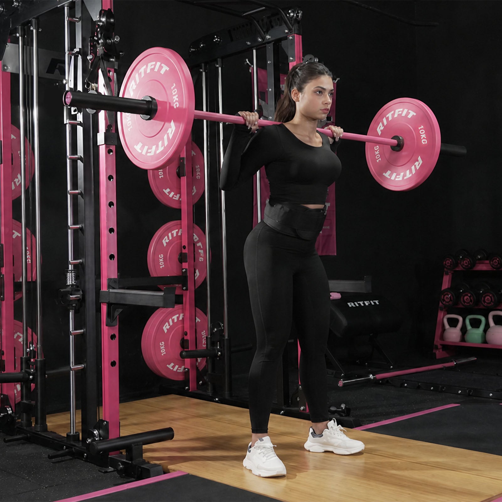 Rosa RitFit Trainings-Langhantel mit Hantelscheiben auf den Schultern einer Frau